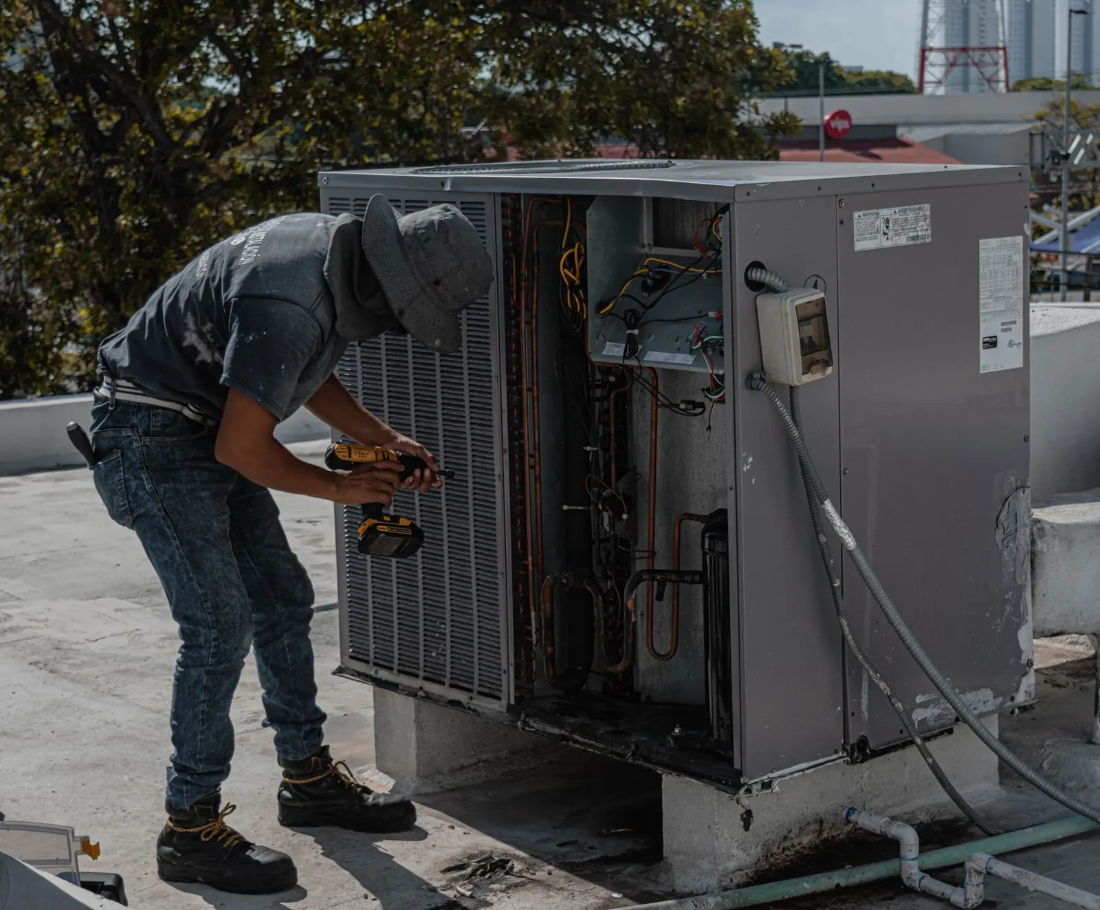 An engineer working on an air conditioning outdoor unit